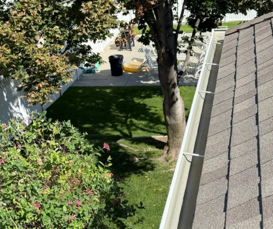 Aerial view of gutter installation on a residential roof by J&A Landscaping, ensuring proper rainwater flow and roof edge protection.